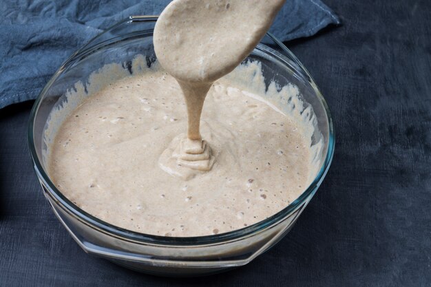 The process of checking the readiness of homemade sourdough for baking rye bread.