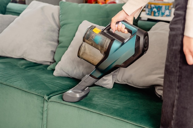 The process of cleaning a sofa with a vacuum cleaner with a special nozzle