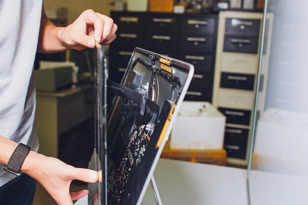 Process of computer repair engineer in white gloves disassembling computer