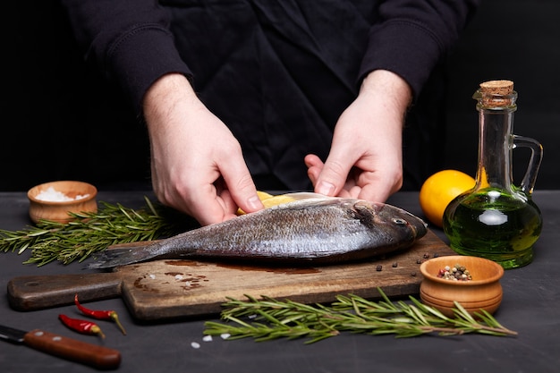 Process of cooking dorado fish with lemon and herbs.