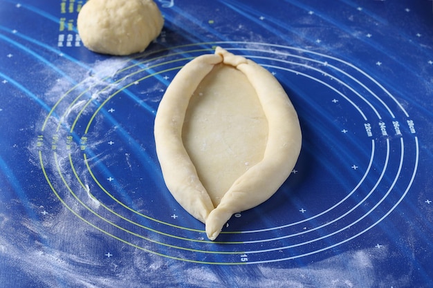 치즈 보트 모양의 파이로 조지아식 카차푸리를 요리하는 과정은 반죽에서 단계별 지침 2단계로 형성됩니다.