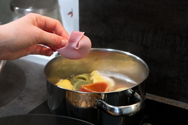냄비에 이탈리아 여러 가지 빛깔의 파스타를 요리하는 과정