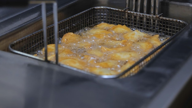 The process of cooking in the kitchen pasties with meat fried in sunflower oil deepfried fast food