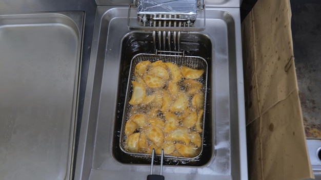 The process of cooking in the kitchen pasties with meat fried in sunflower oil deepfried fast food