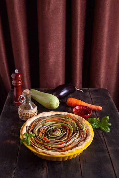 The process of cooking a vegetable spiral pie with zucchini eggplant carrots with basil in a silic