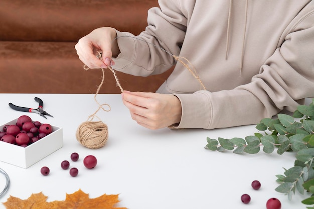 The process of creating an autumn decorative wreath on a white table