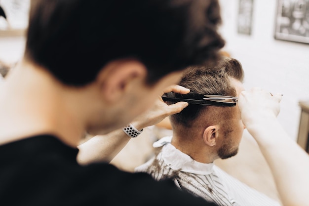 Процесс стрижки волос ножницами парикмахер для мужской парикмахерской