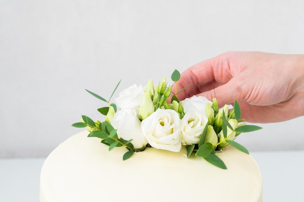 Процесс украшения торта цветами крупным планом Сладкий торт с цветочным декором