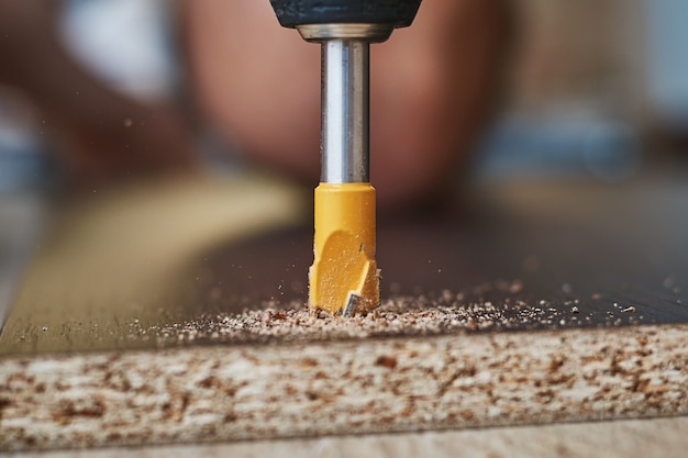 Process of drillig wood with a drill bit close up