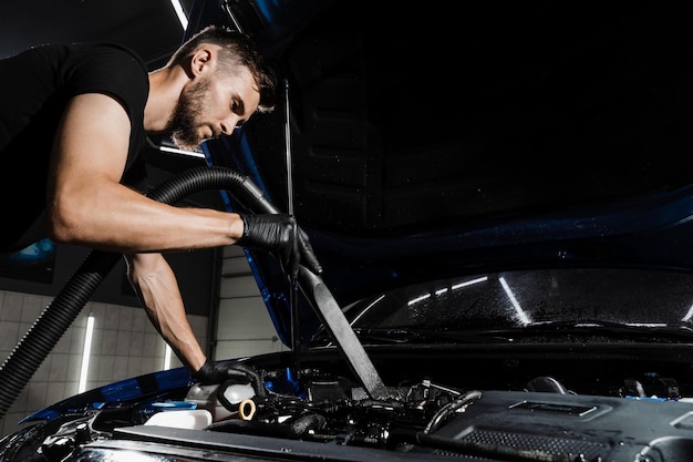 Process of drying car engine after washing with water and chemical detergent Detailing cleaning motor from dust and dirt