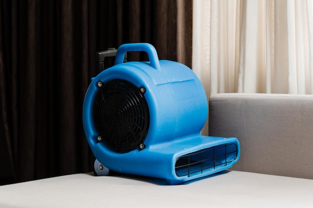 Process of drying sofa using floor dryer blower fan machine Floor dryer blower fan machine drying wet couch after dry cleaning of upholstered furniture