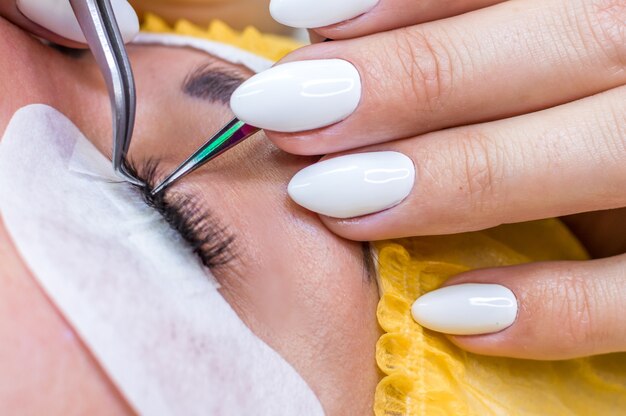 Process of eyelash extension. tweezers for close-ups