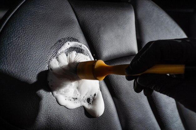 Premium Photo  Process of foam and detergent cleaning leather seat using  brush worker in auto cleaning service clean car inside car interior  detailing