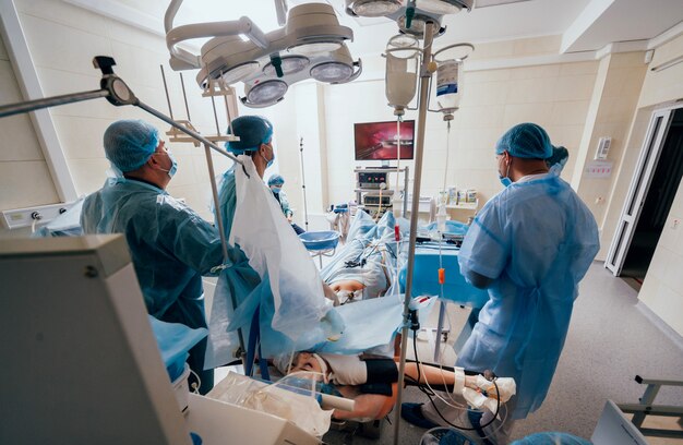 Process of gynecological surgery operation using laparoscopic equipment. Group of surgeons in operating room with surgery equipment