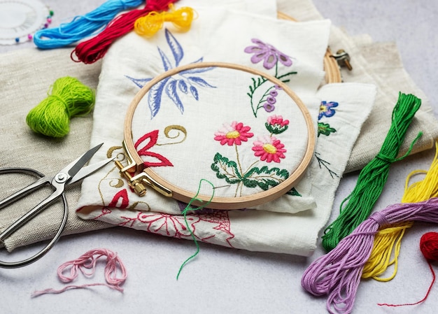 The process of hand embroidering a napkin with colored threads on white fabric