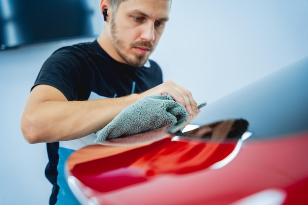 The process of installing protective film on the new red car