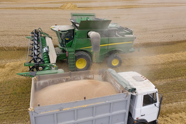 Photo process of loading grain from the combine to the tractor trailer