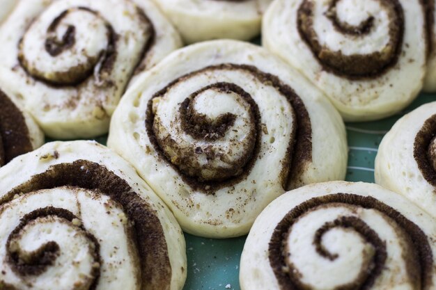 Foto il processo di preparazione dei cinnabon pasta per rotoli alla cannella su una teglia da forno