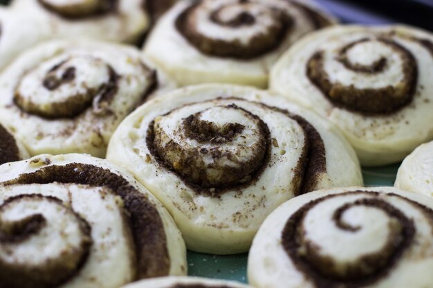 Foto il processo di preparazione dei cinnabon pasta per rotoli alla cannella su una teglia da forno