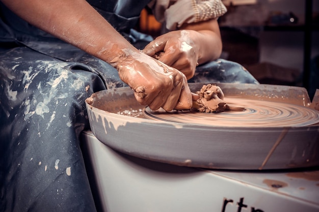 Photo the process of making a clay jug on a potter's wheel. close-up.