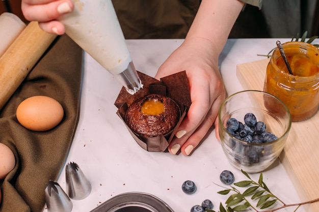 Process making homemade chocolate cupcake with cream