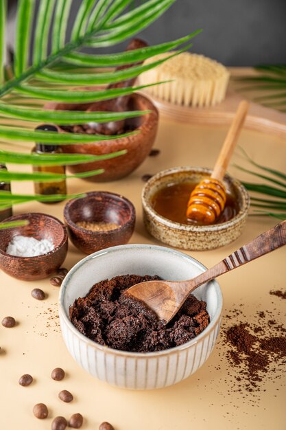 The process of making a homemade coffee scrub for skin care ecofriendly cosmetics vertical photo