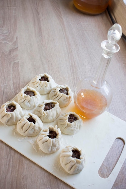 The process of making homemade dumplings Raw homemade dumplings on a wooden board Molding dumplings