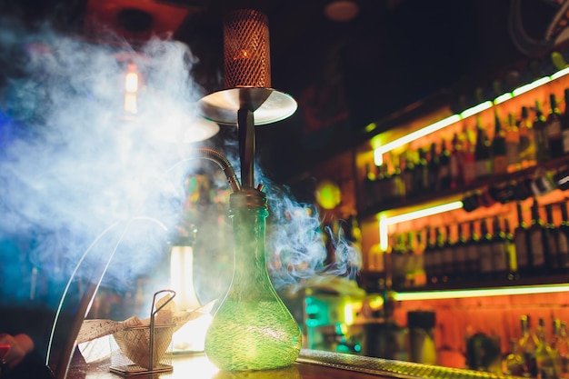 Process of making hookah for smoking concept of smoking a hookah and having a good time hookah bowl on the dark background of the bar close up view Toned image