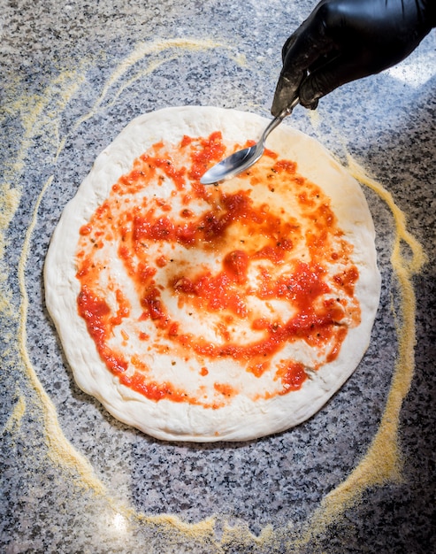 Photo the process of making pizza. hands of chef baker making pizza at cafe kitchen