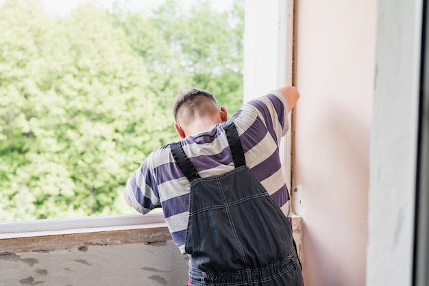 Photo process male worker repairing window in a house, close up