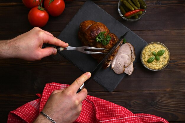 the process of a man cutting roast beef view from above