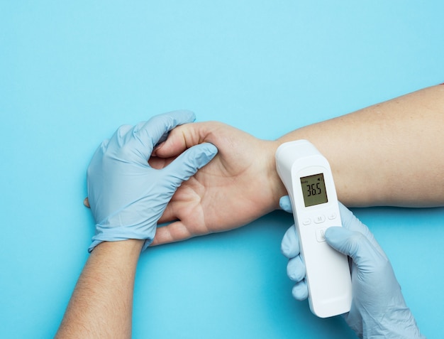 Process of measuring body temperature on the wrist with a non-contact thermometer, close up