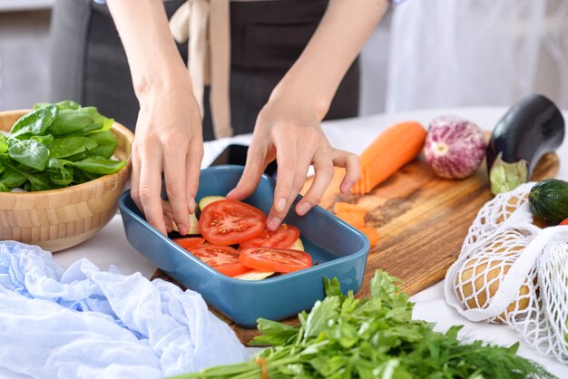 사진 베이킹 접시에 배치 토마토 손으로 야채를 요리하는 과정