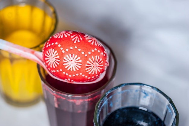 The process of painting Easter eggs with food coloring and melted wax.