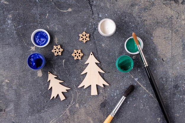 Foto il processo di pittura dei giocattoli di legno per l'albero di natale