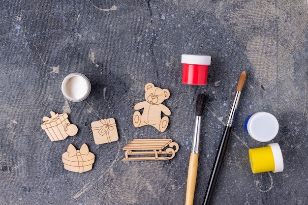 Photo the process of painting wooden toys for the christmas tree