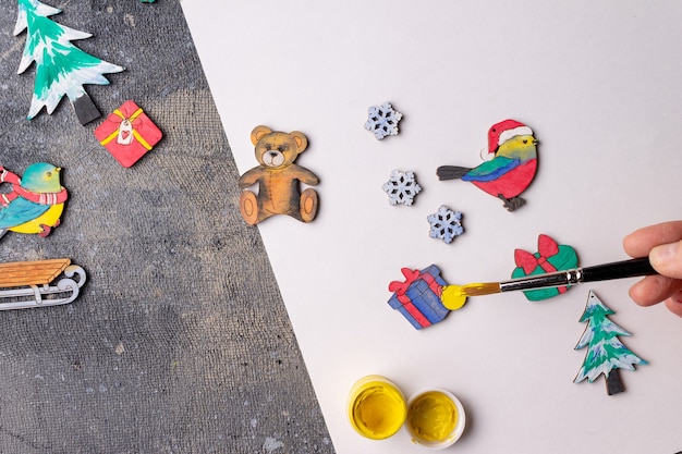 Photo the process of painting wooden toys for the christmas tree