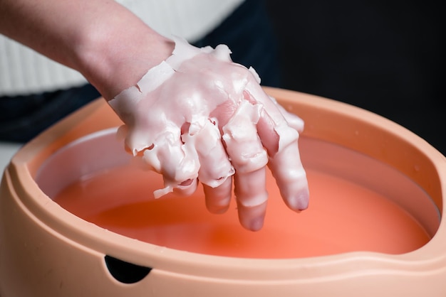 Process paraffin treatment of female hands in beauty salon