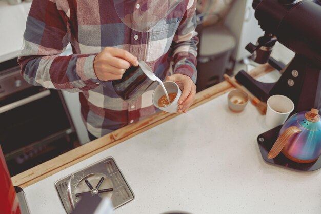 Process of pouring milk into cappuccino in cafe