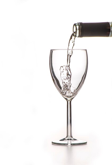 Photo the process of pouring wine into a glass on a white background a large space for text on the left