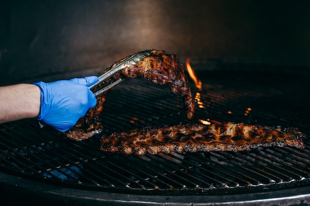 Process of preparing pork ribs on an open fire on grill