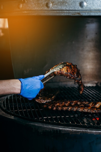 Process of preparing pork ribs on an open fire on grill