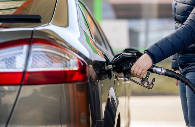 ガソリンスタンドのポンプ充填燃料ノズルでガソリン燃料を車に燃料補給するプロセス...