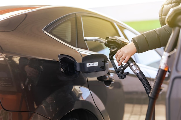 연료 노즐을 연료로 채우는 주유소 펌프에서 가솔린 연료로 자동차 충전물에 연료를 보급하는 과정