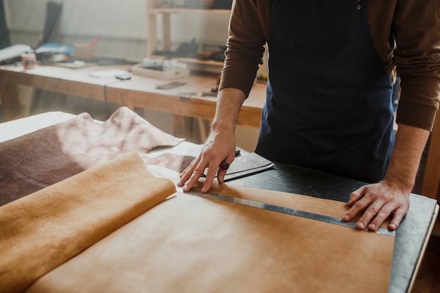 Process of revealing piece of leather in workshop