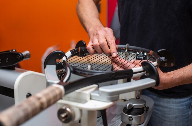 The process of stringing a tennis racket in a tennis shop