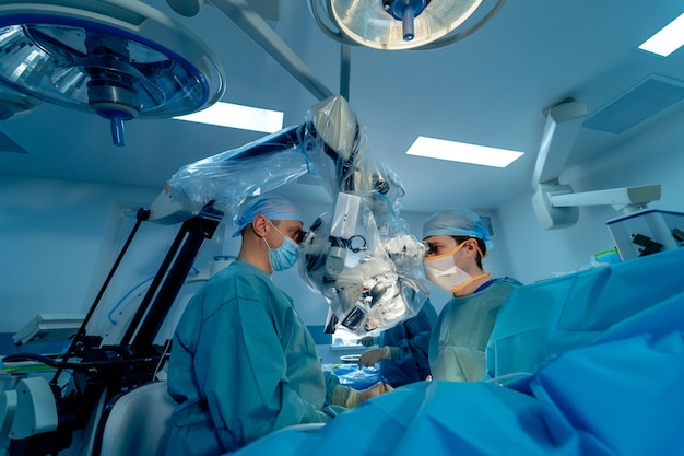 외상 수술 수술의 과정. 수술 장비가 있는 수술실에 있는 외과의사 그룹입니다. 의료 배경, 선택적 초점