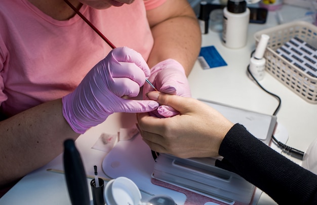 the process of a woman's manicure, gel varnish. care for the nails, lamp, varnishes, tools, nail covering.