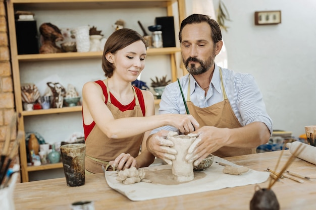 Process of work. Two beaming professional potters feeling simply amazing enjoying the process of work