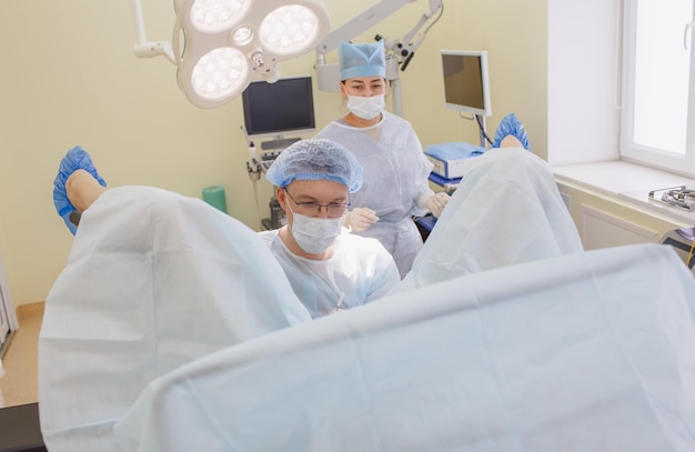 A proctologist and a nurse perform an operation in the operating room